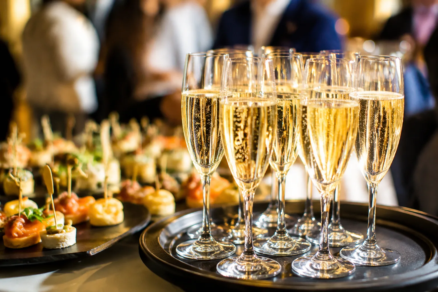 A photorealistic image of passed hors d'oeuvres and a champagne toast setup at a New Year's Eve catered party, with sparkling wine glasses